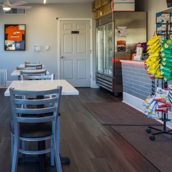 Interior of Johnny's Pockets with dining tables, a chip rack, and a large refrigerator.